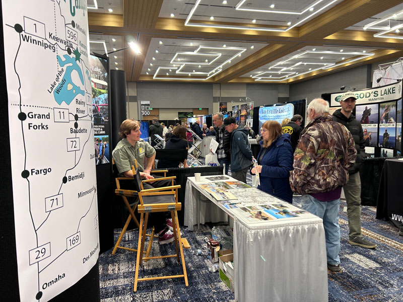 View from a sports tradeshow aisle full of exhibitors and patrons