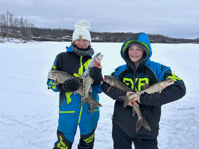 Two girls holding four fish between them