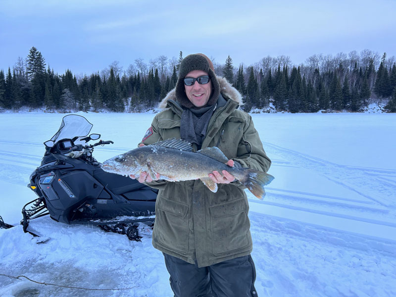 Large walleye picture caught through ice fishing hole