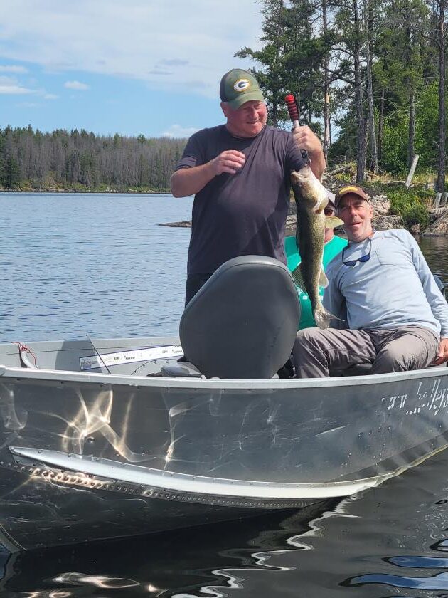 Fishermen fishing in Halley's Camps Trapline Lake Outpost holding a Canadian Walleye.