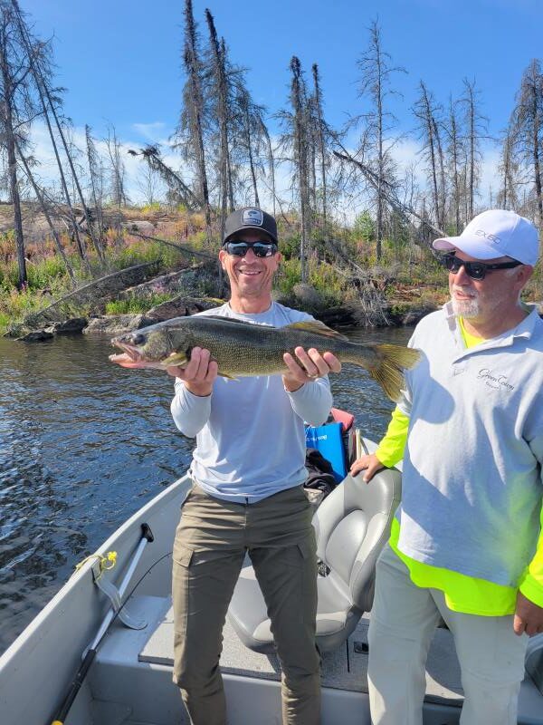 2 Fishermen in Halley's Camps boat at Trapline Lake Outpost and one is holding a Canadian walleye.