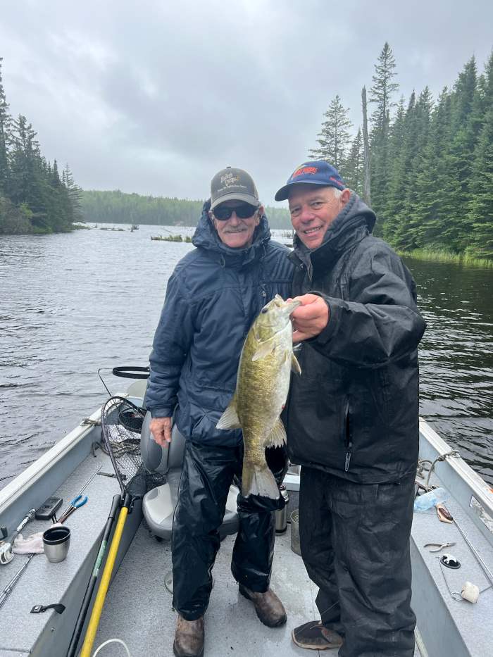 2 Men fishing the English River holding up at Smallmouth bass