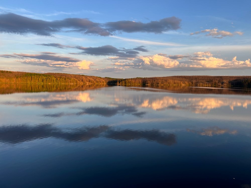 Calming photo taken at Rex Lake Outpost with cloud reflections on the water.