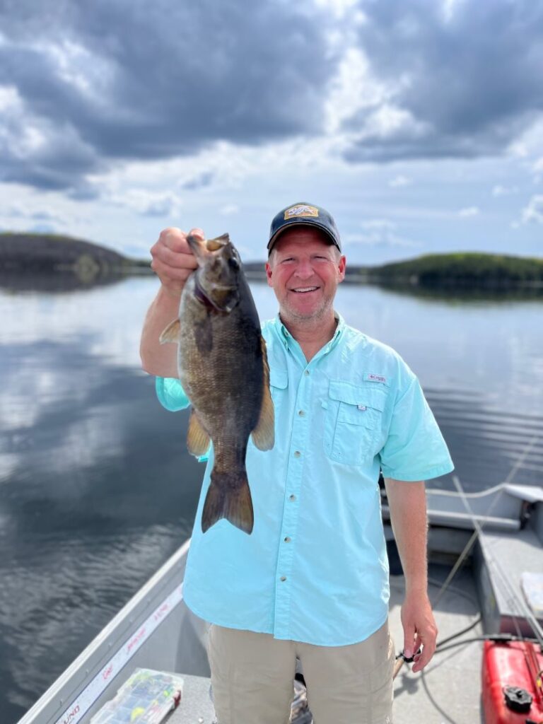 Fisherman on Rex Lake holding smallmouth bas