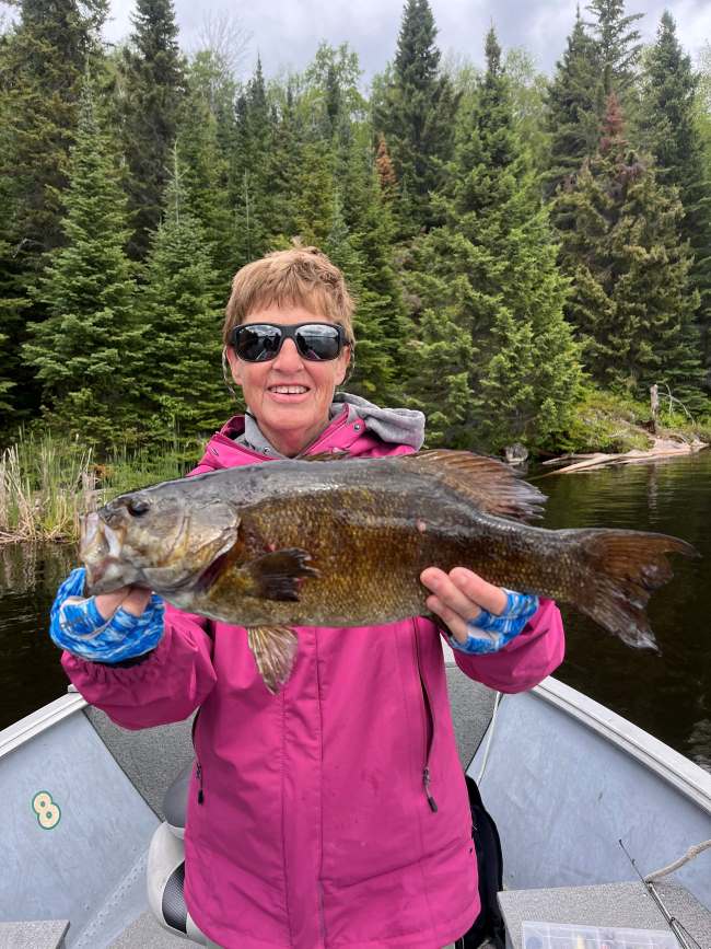 Cary fishing and holding up a smallmouth bass fishing spring time.