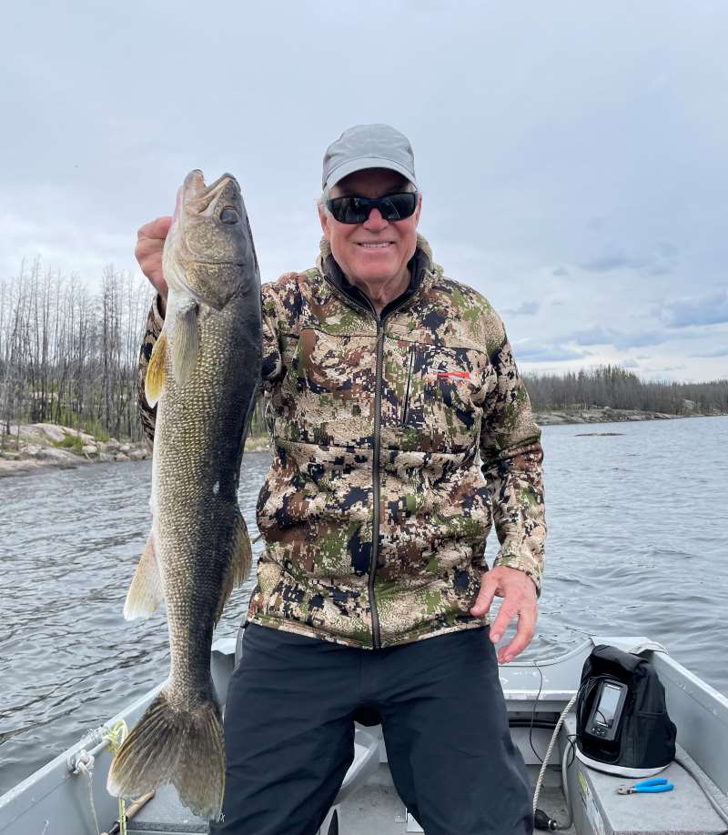 John holding up walleye in a boat on Trapline Lake