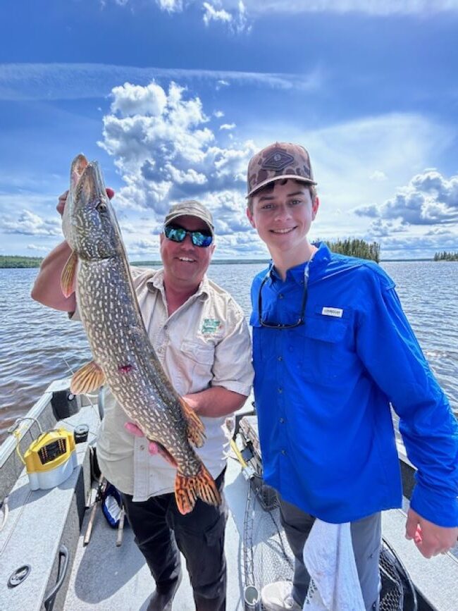 Fisherman holding up trophy northern pike at Halley's Camps One Man Lake.