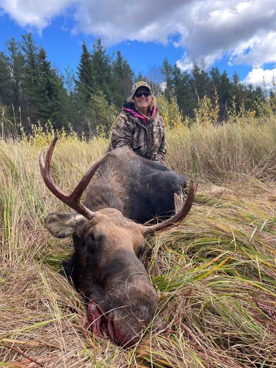 Woman posing with her moose she shot at Halley's Camps!