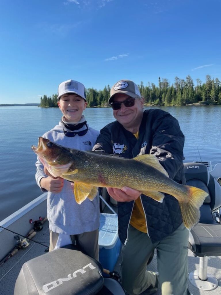 Guide and fisherman holding up a big walleye at One Man Lake Lodge