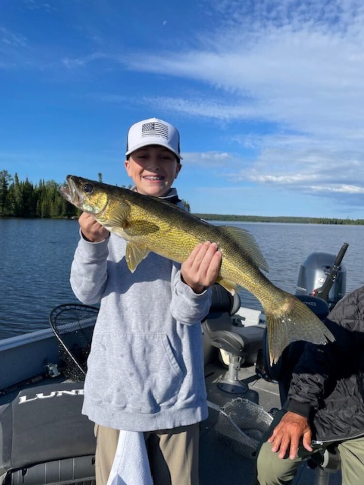 Fisherman holding up a walleye at Halley's Camps One Man Lake.