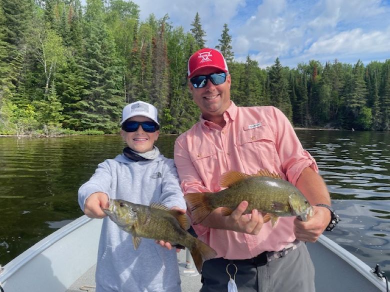 Father son duo holding up smallmouth bass fish at Halley's Camps.