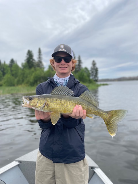 Fisherman holding up a fish at Halley's Camps One Man Lake.