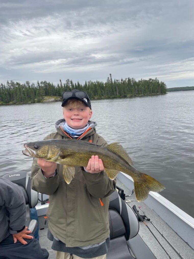 Fisherman holding up a walleye at Halley's Camps One Man Lake.