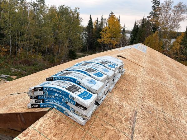 Pile of shingles on the roof that need to be installed at Dufault's Island