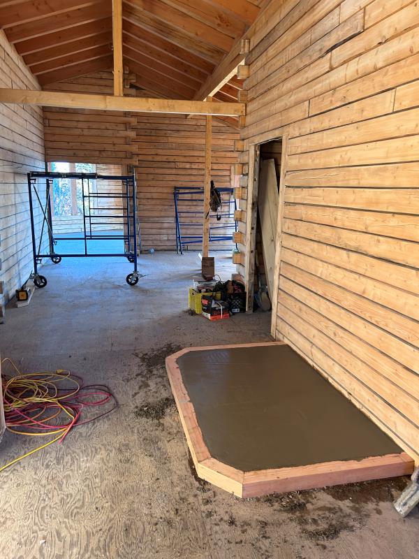 Dufualt's interior picture of cabin with wood stove cement pad