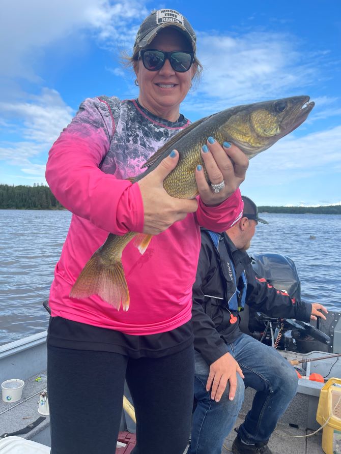 Woman who is Canadian Fishing at Halley's Camps holding a trophy walleye.