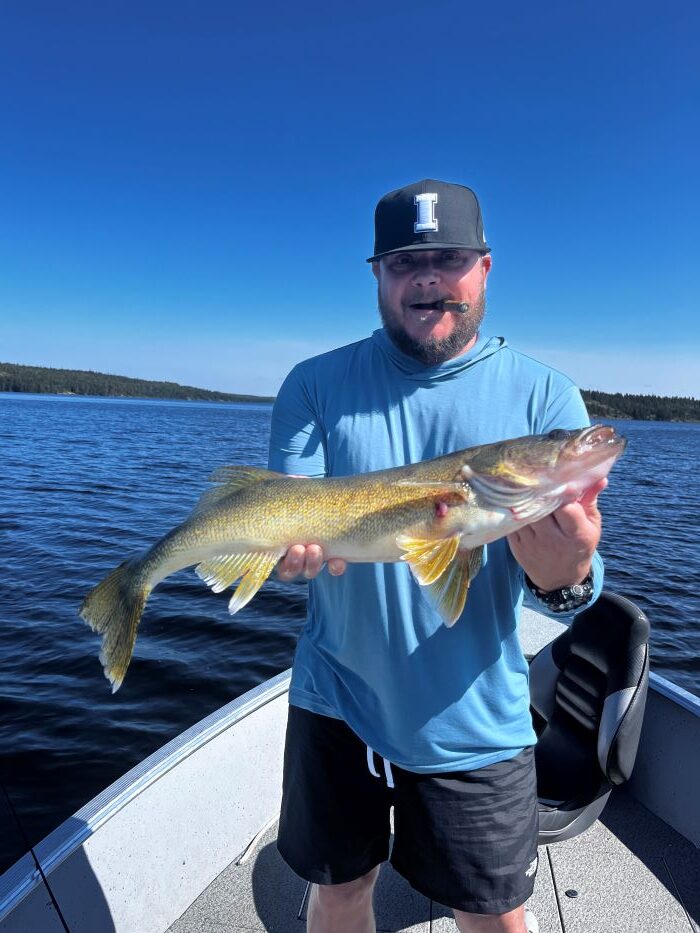 Trophy Walleye being held by a fisherman in a boat at Halley's Camps Caribou Falls Landing.