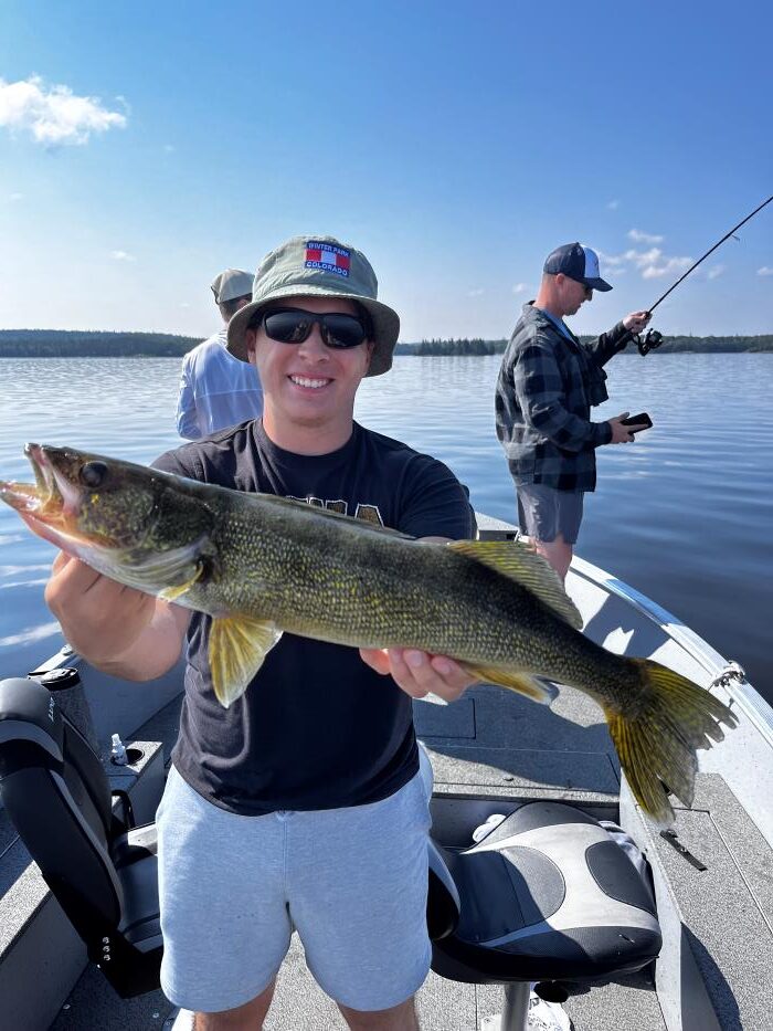 Trophy Walleye being held by a fisherman in a boat at Halley's Camps Caribou Falls Landing.