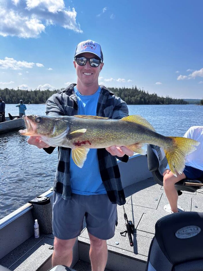 Trophy Walleye being held by a fisherman in a boat at Halley's Camps Caribou Falls Landing.