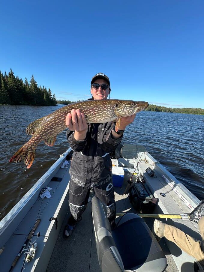 Fisherman and his trophy northern pike caught in a boat at Halley's Camps Kettle Falls Lodge.