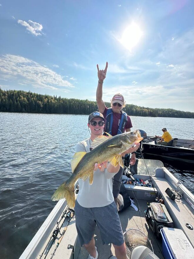 Fisherman and his Canadian trophy walleye caught in a boat at Halley's Camps Kettle Falls Lodge.