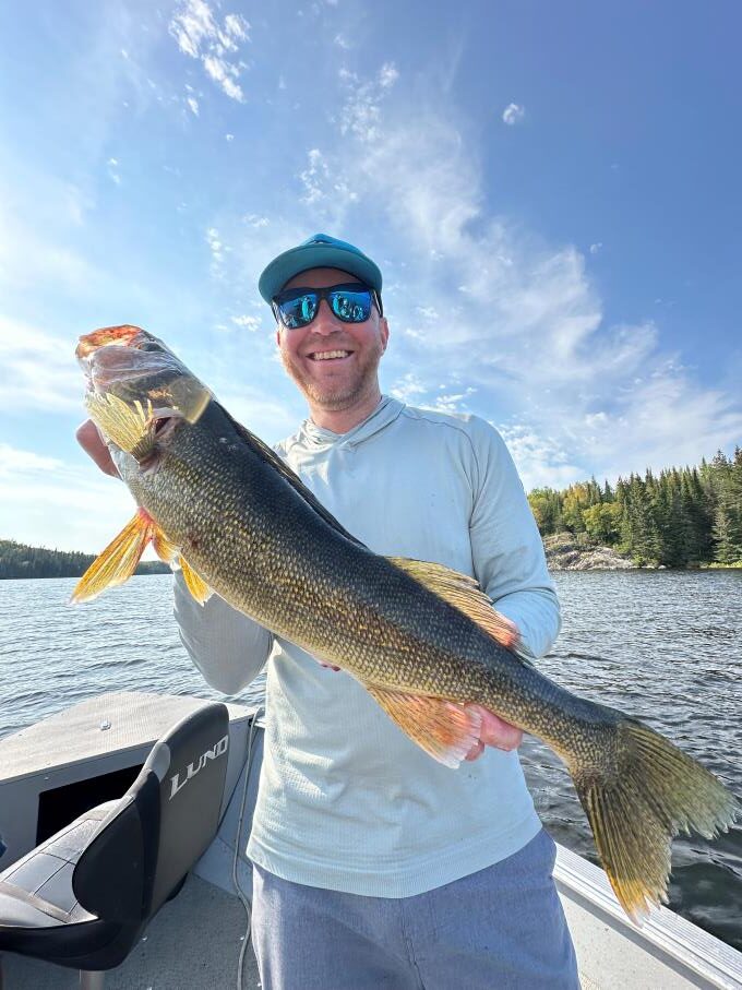 Fisherman and his Canadian trophy walleye caught in a boat at Halley's Camps Kettle Falls Lodge.