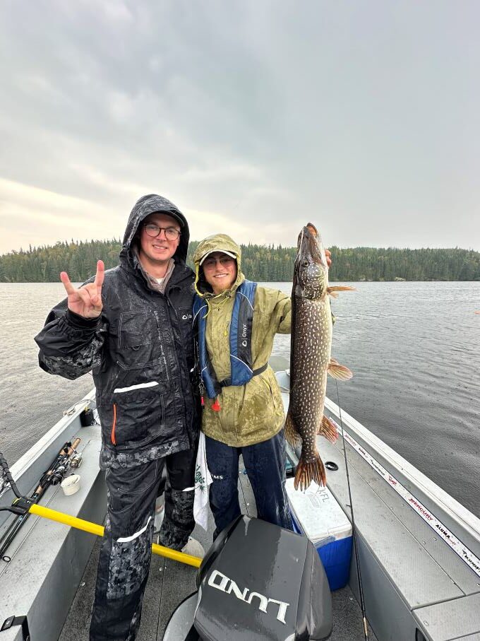 Fisherman and his trophy northern pike caught in a boat at Halley's Camps Kettle Falls Lodge.