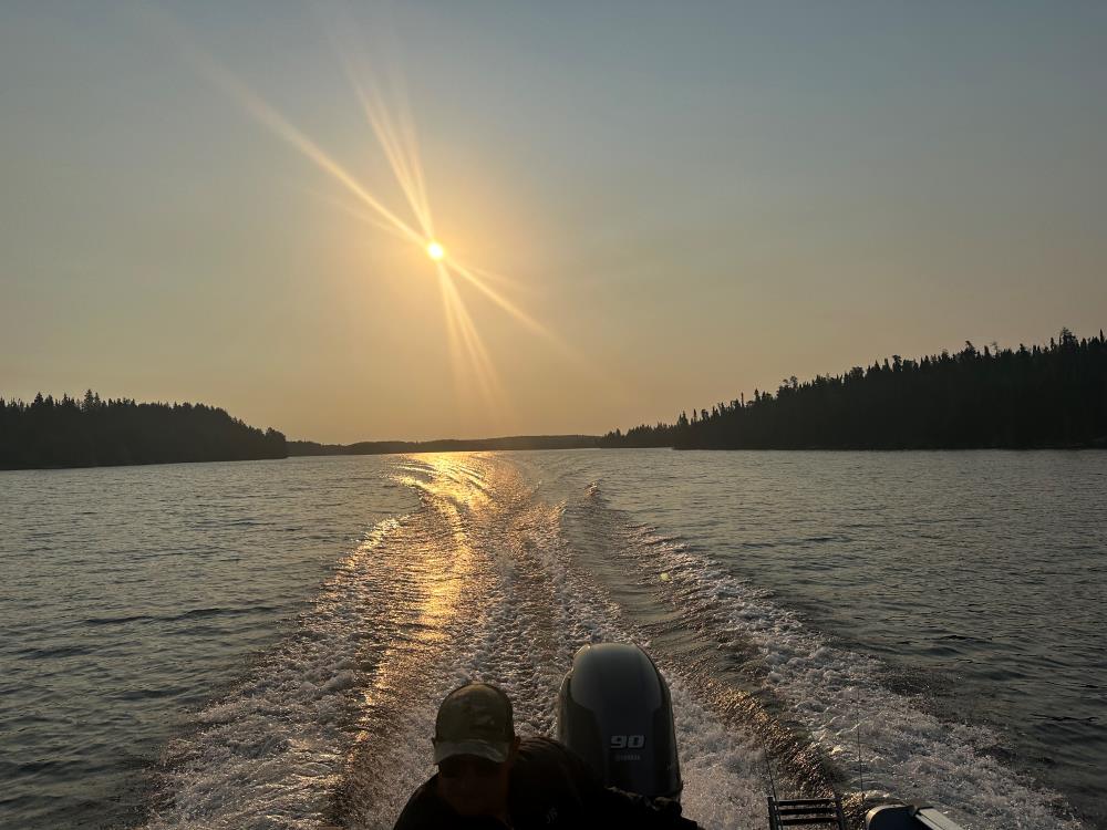 Sunset behind boat waves on the English River at Kettle Falls.