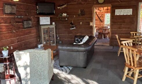 Interior of lodge with tv, chairs, tables, couch