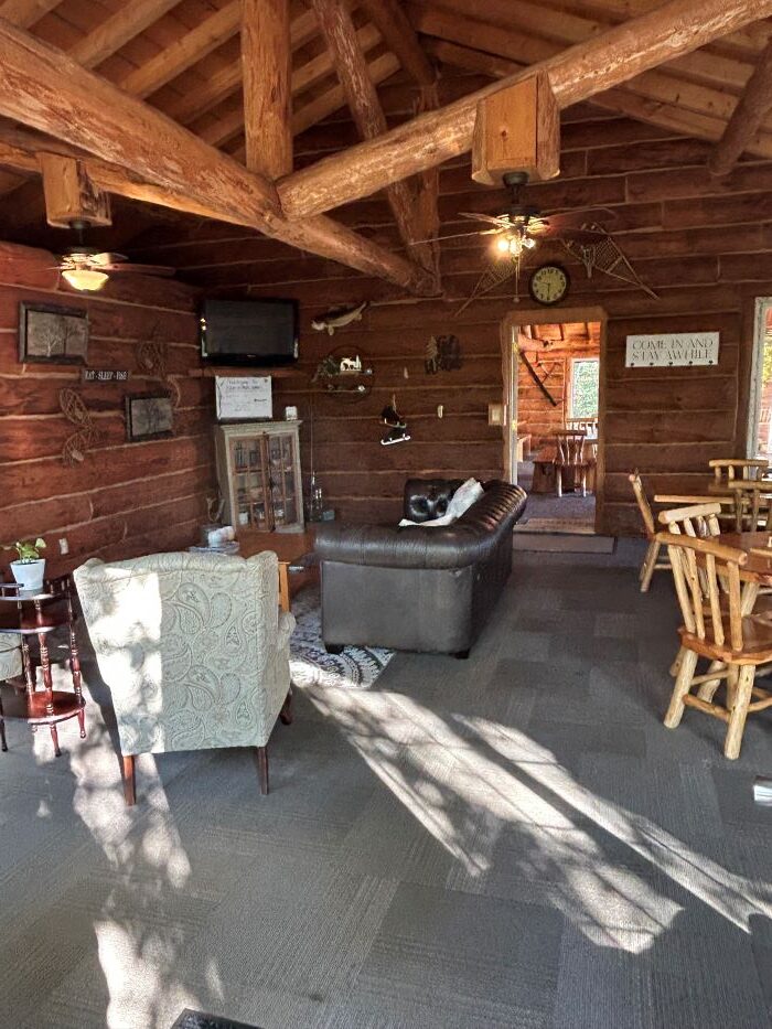 Interior of lodge with tv, chairs, tables, couch