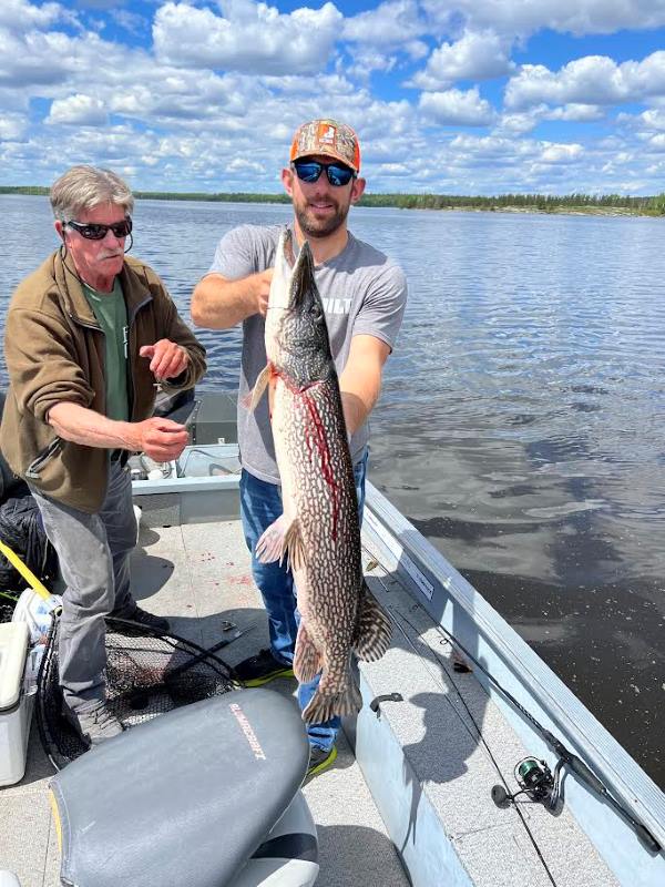 Nate and guide Brian holding up Nate's big catch-a trophy northern pike!