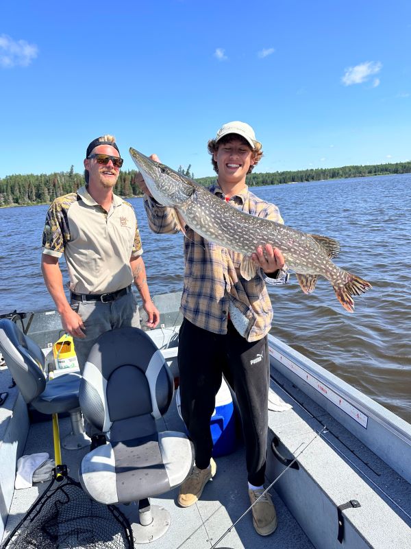 Man and his guide holding Trophy Northern Pike at Halley's Camps Kettle Falls Lodge.