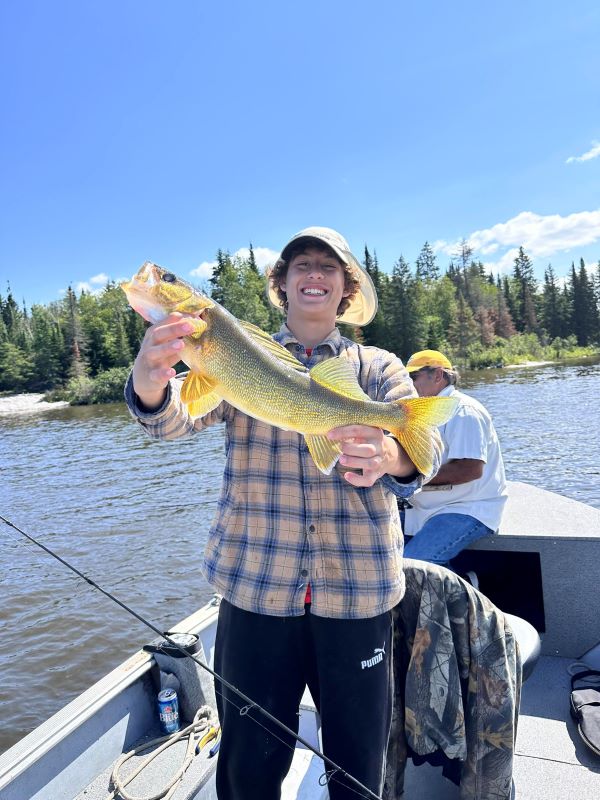 Man holding a walleye with hints of yellow and gold in color.