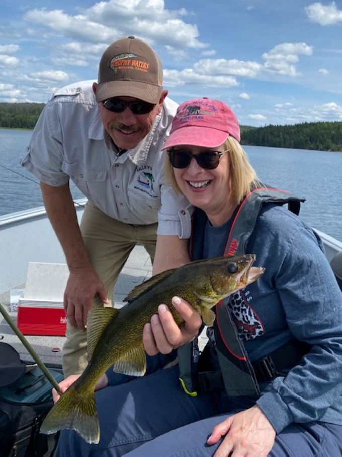 Husband and wife fishing trip at Halley's Camps with them in the front of the fishing boat on One Man Lake.