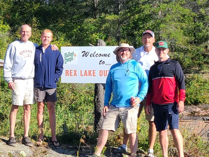 Fishing crew posed in front of the Halley's Camps Rex Lake Outpost sign!