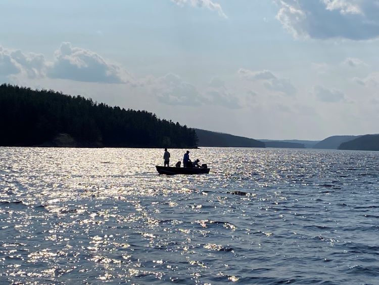 Boat in the distance with fishermen fishing at Rex Lake Outpost.