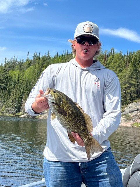 Young man holding a nice size bass in spring fishing.